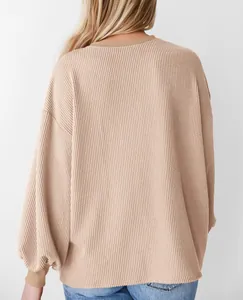 Achteraanzicht van een losse beige top met lange mouwen en een fijne geribbelde textuur