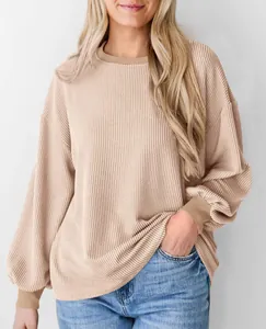 Detailopname van oversized geribbelde T-shirt met lange mouwen in beige stof
