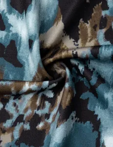 Close-up detail of blue and brown tie-dye fabric texture for women's V-neck blouse