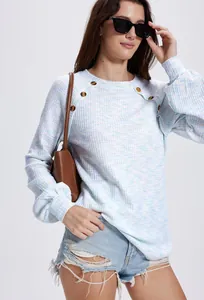 Detailweergave van wafelgebreid damesshirt met lange mouwen en decoratieve knopen