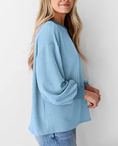 Detailweergave van de blauwe getextureerde wafelgebreide losse sweatshirt met mouw