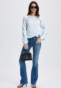 Detail van casual wafelgebreid damesshirt met lange mouwen, raglanmouwen en knoopsluiting