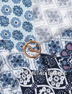 Macro view of a golden metal buckle on a blue floral print tunic blouse details