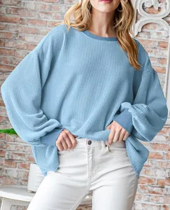 Gedetailleerd overzicht van lichtblauw gestructureerd ruimvallend sweatshirt op het model