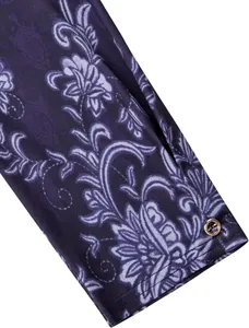 Close-up of purple floral print shirt sleeve detail with decorative gold button