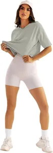 Vollständige Detailansicht einer Frau in lockerem grauem Sport-T-Shirt und weißen Yoga-Shorts