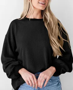 Detailopname van een zwart gestructureerd sweatshirt met lange mouwen in wafelbreisel