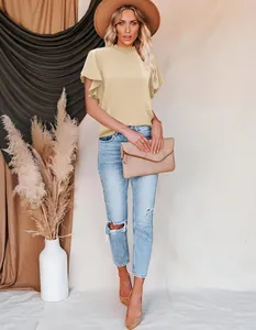 Close-up showing the elegant pleated collar and ruffled sleeves of the beige blouse