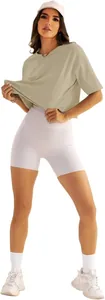 Ganzkörperansicht einer Frau in olivfarbenem Oversize-T-Shirt und weißer Radlerhose
