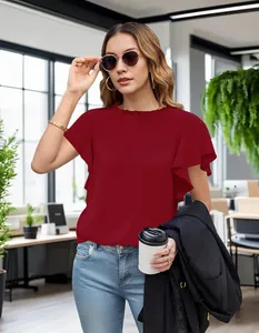 Model wearing a red ruffled collar blouse and sunglasses in a stylish office environment