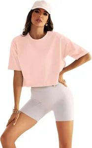 Ganzkörperaufnahme eines Models mit rosa lockerem Yoga-Crop-Top und grauen Radlershorts