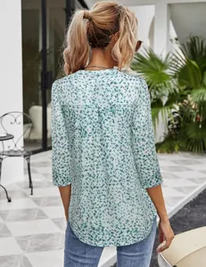 Back view of floral printed 3/4 sleeve tunic blouse for women in an outdoor setting.