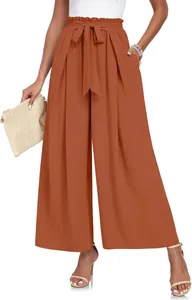 Gros plan d'un pantalon large plissé à taille haute élégant avec ceinture à nœud orange