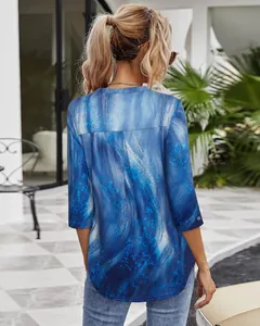 Back view of a blue abstract print 3/4 sleeve shirt for women in a patio setting