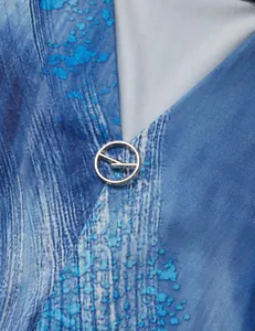 Close-up of blue marble print V-neck blouse featuring a decorative silver metal buckle