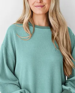 Detailopname van de groenblauwe wafelgebreide textuur van deze casual top met lange mouwen