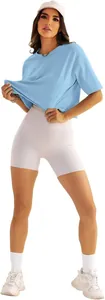 Detailansicht einer Frau in einem blauen Oversized-T-Shirt und weißen Biker-Shorts