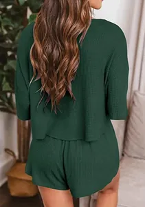 Vista posteriore dettagliata di un set da casa in maglia a nido d'ape verde scuro da donna