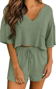 Dettaglio del set due pezzi da donna in maglia a nido d'ape verde salvia con scollo a V