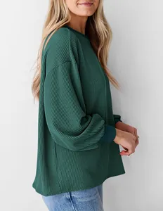 Zij-aanzicht van een donkergroen gewafeld sweatshirt met textuur en pofmouwen.