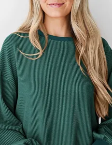 Gedetailleerde weergave van groene wafelbreitextuur op een losse casual top met mouwen
