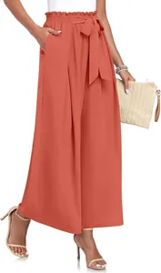 Détail du pantalon large orange à taille haute avec ceinture à nœud et texture plissée