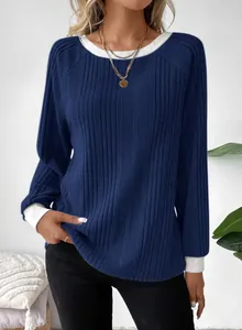 Detailopname van een blauw geribbeld shirt met lange mouwen en witte halslijn details