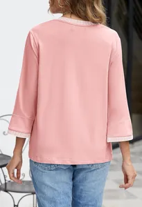 Rear view of a pink round neck top with striped ribbed trim on sleeves and collar