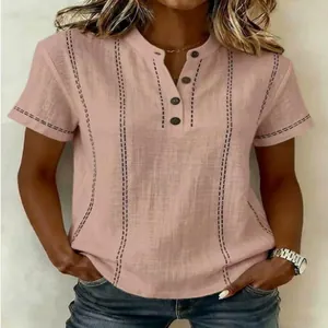 Vue détaillée d'une chemise en lin rose avec des surpiqûres décoratives perlées.