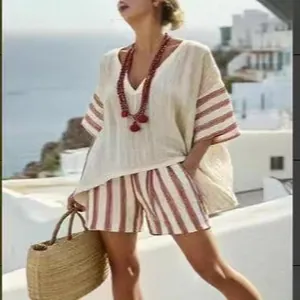 Casual women's summer set featuring a loose V-neck top and red striped shorts outdoors
