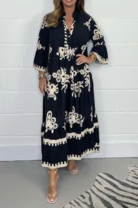Vue détaillée d'une robe longue noire élégante à manches longues et motifs beiges