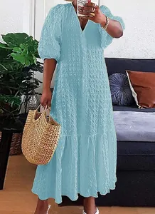 Detail van lichtblauwe maxi-jurk met V-hals en knopen in een casual huiselijke sfeer