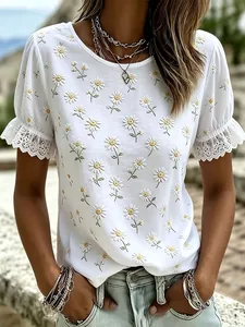 Close-up detail of white summer top with daisy print and elegant lace trim sleeves