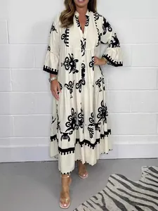 Robe longue crème élégante avec imprimé floral noir col montant et jupe à plusieurs niveaux