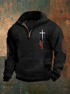 Gedetailleerde macro-opname van zwarte herenhoodie met wafelgebreid kruis- en vlagprint