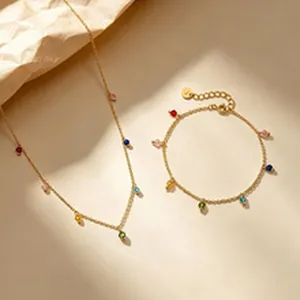 Vista dettagliata del set collana e bracciale dorato con perline arcobaleno colorate