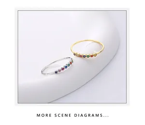 Détail de bagues en argent S925 et or avec une rangée arc-en-ciel de pierres