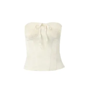 Close-up of white strapless corset top with smocked bust and delicate bow detail