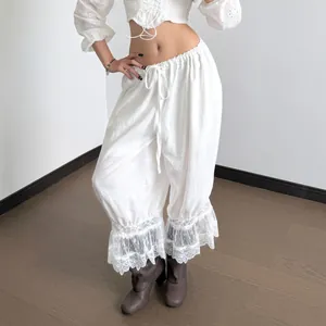 Vista detallada de pantalones casuales blancos de cintura baja con bajos de encaje.