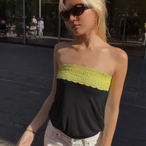 Chic color-block tube top with neon yellow lace trim worn by a model in urban setting
