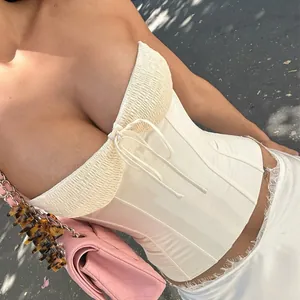 Detail view of a sexy French style off-white corset bustier top with ruffled bust.