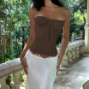 Detail view of a French-style brown strapless corset top paired with a white lace skirt.