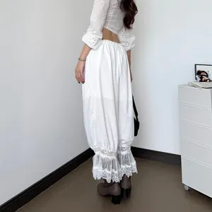 Vista detallada del pantalón informal blanco de talle bajo con empalmes de encaje fino.