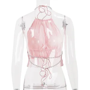 Dettaglio posteriore di top halter rosa pieghettato con perle e lacci