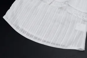 Detailed close-up showing white sheer ribbed fabric and delicate floral lace trim detail