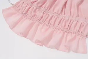 Primo piano della texture plissettata e dell'orlo a balze di un top estivo rosa sexy