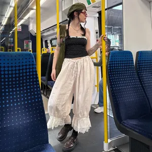 Detalle de pantalones casuales blancos con encaje y cintura baja en estilo urbano de moda.