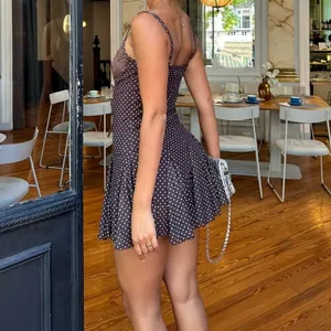 Detailed view of a stylish brown polka dot mini dress featuring delicate lace trim