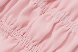 Vista dettagliata del tessuto rosa arricciato e delle cuciture fini su un top estivo