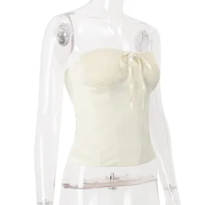 Elegant cream-white strapless corset tube top featuring a smocked bust and bow detail